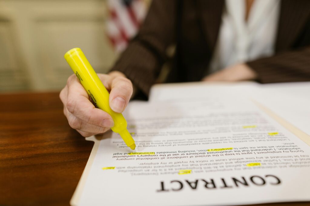 A contract on a table with someone highline lines on the page.
